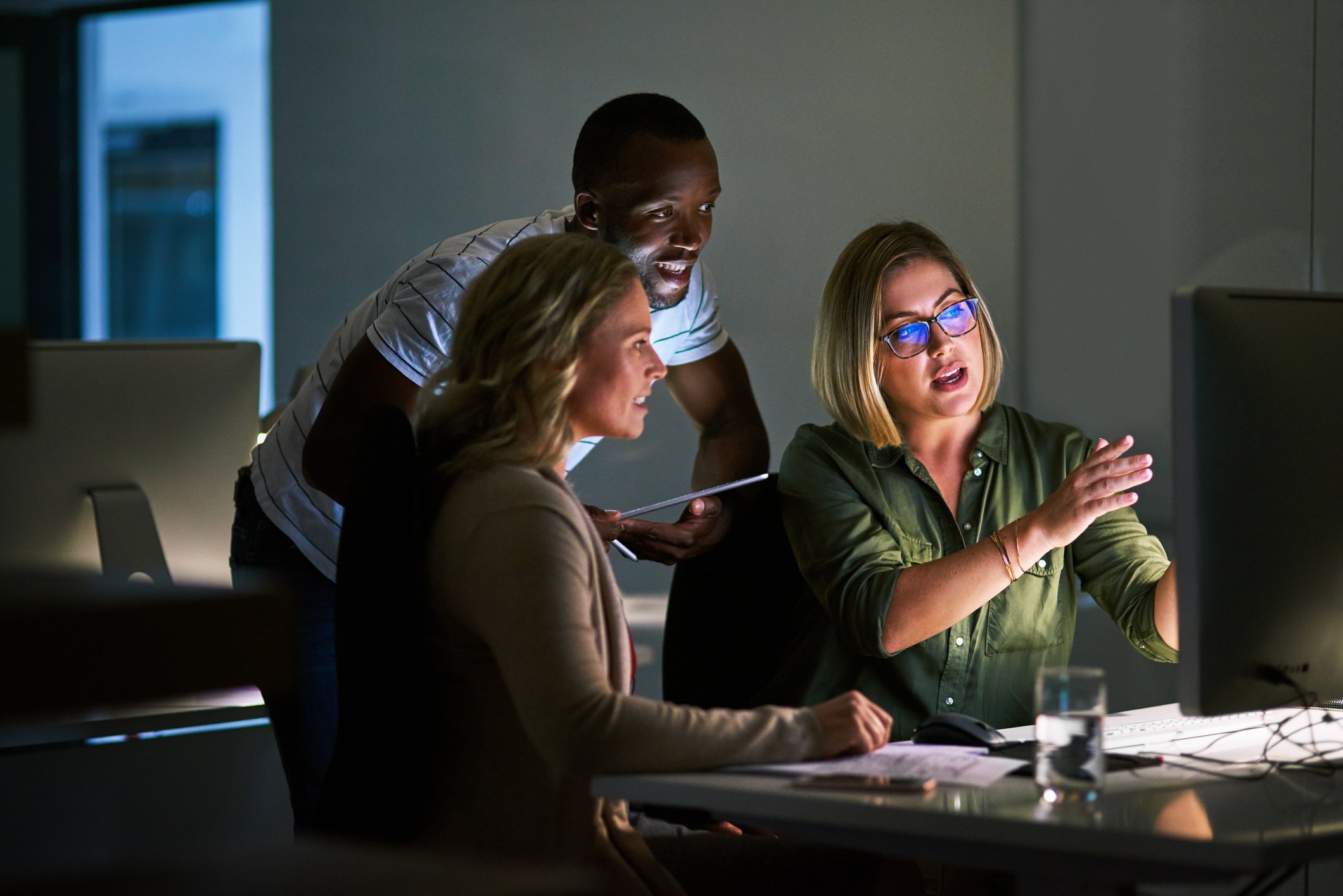 A team of three people looking at a computer screen